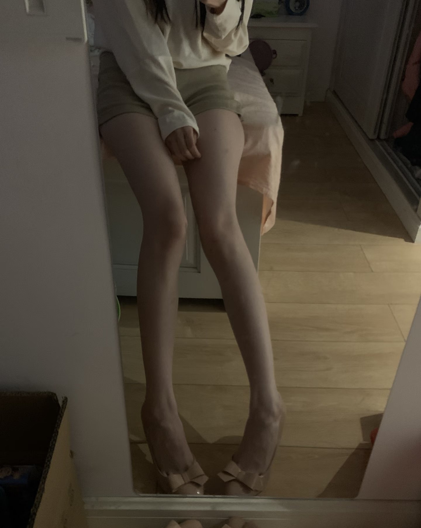 长腿的女人坐在床上。