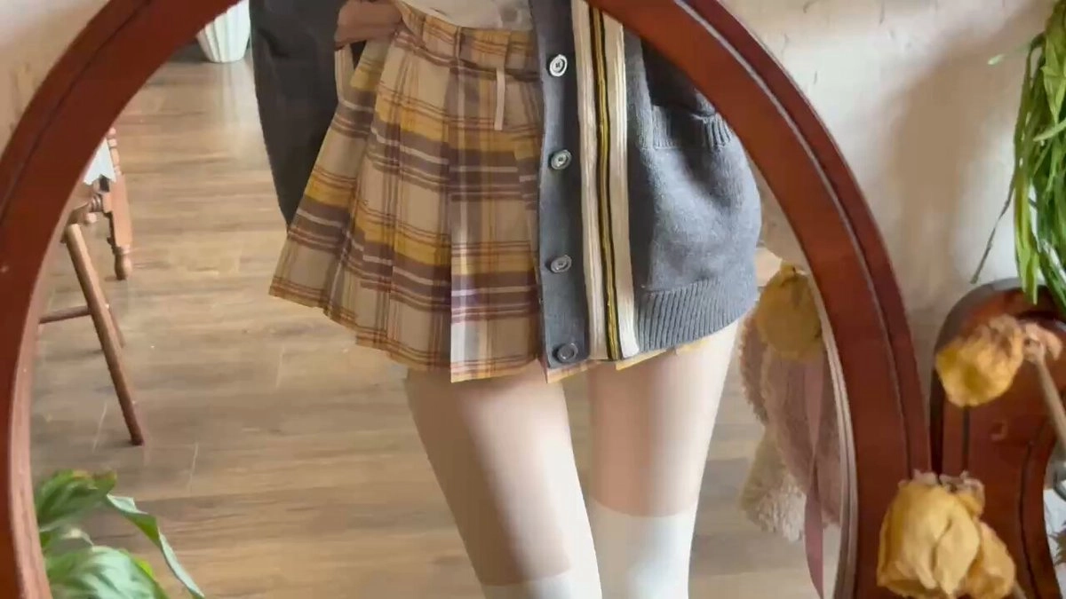 穿着灰色衬衫和黄色裙子的女人。