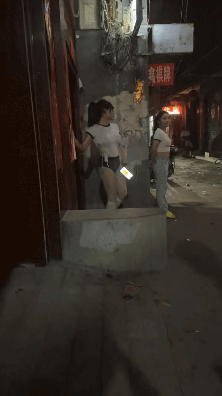 两个女人站在一边,拿着手机。