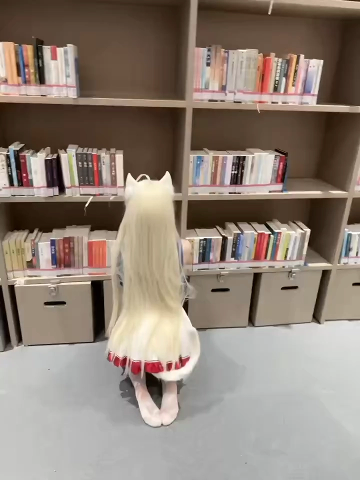 金发长的女孩在书架前跪下。