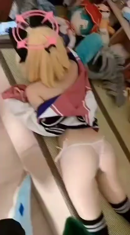 一位穿着黑色帽子和粉红色衬衫的女人躺在床上。