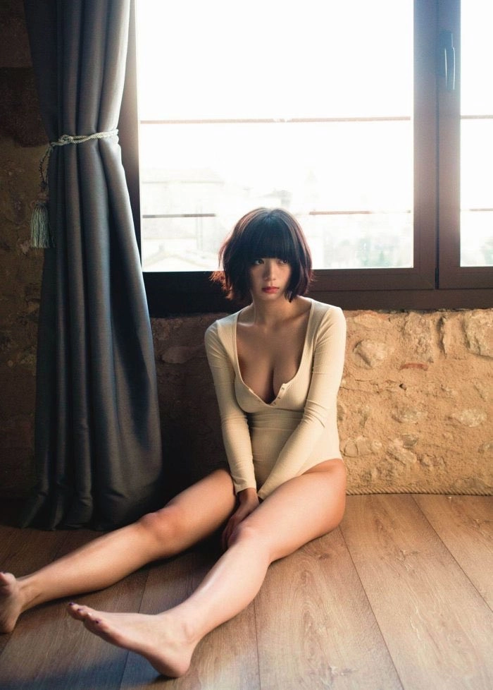 穿着白色衬衫的女人坐在木地板上。