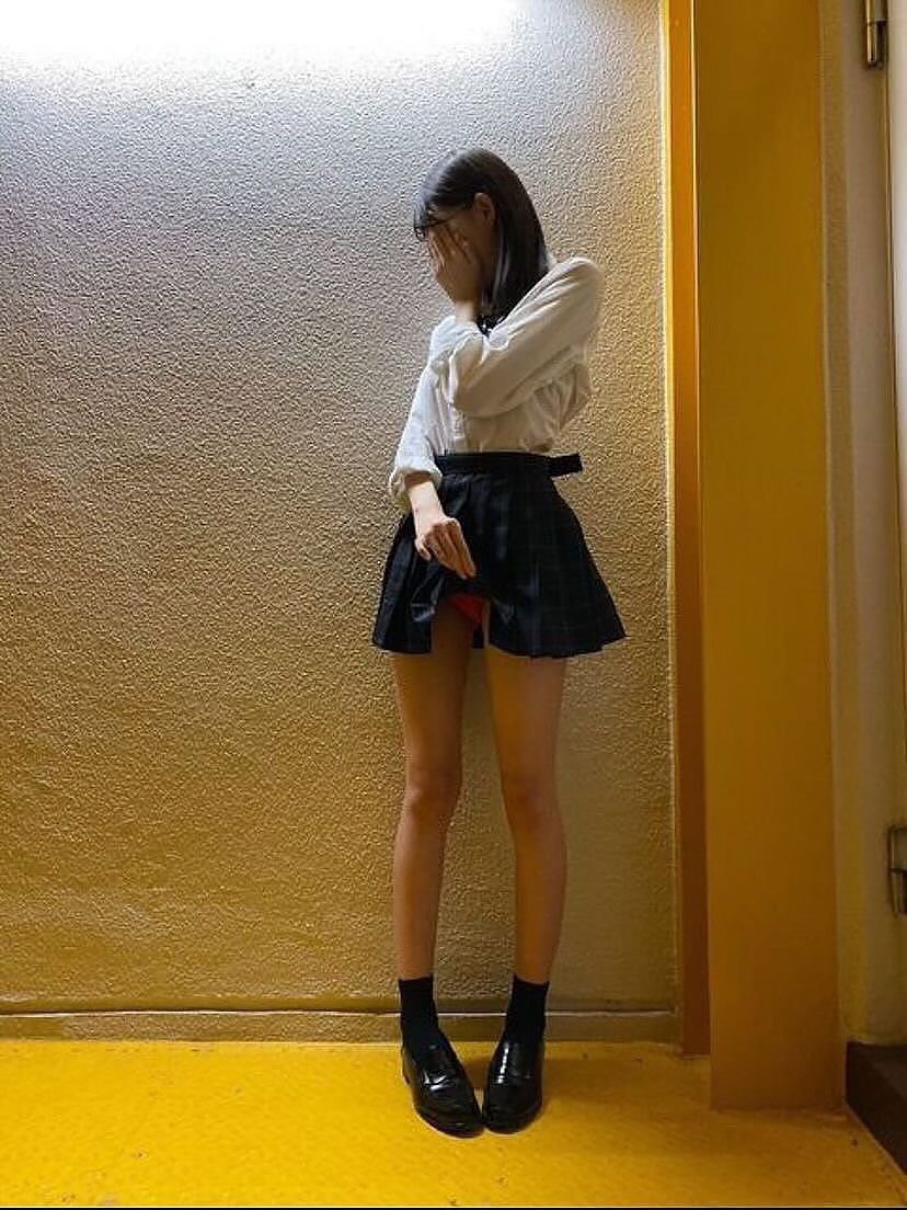 戴着黑色裙子和白色衬衫的女人遮住她的嘴巴。