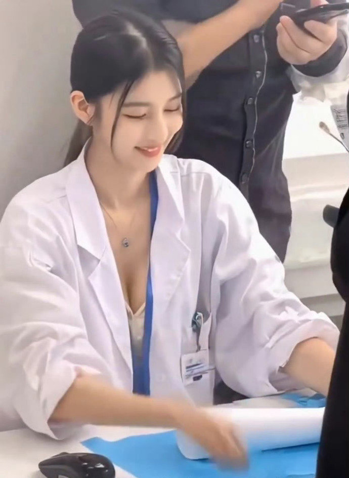 一位穿着实验室外套的女人微笑着抱着一件蓝色布。