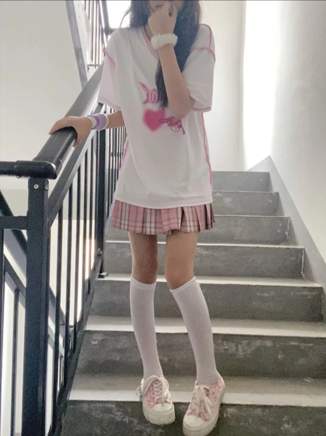 女孩穿着一件白色的衬衫,上面有一颗粉红色的心。