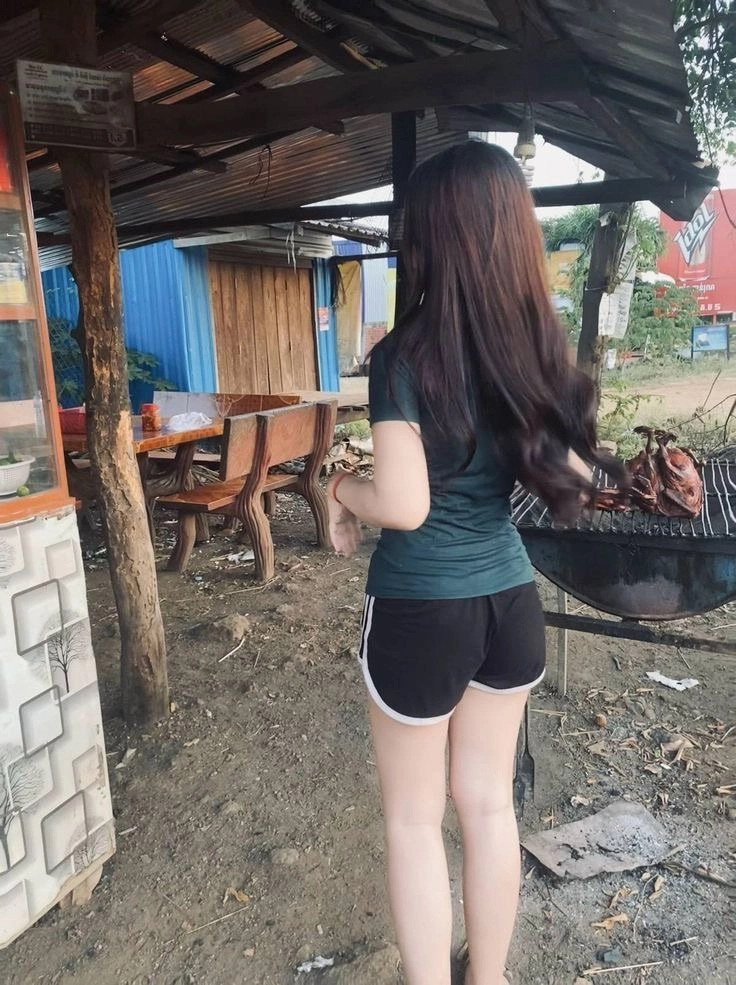 穿着绿色衬衫的女人穿过一个烤箱。