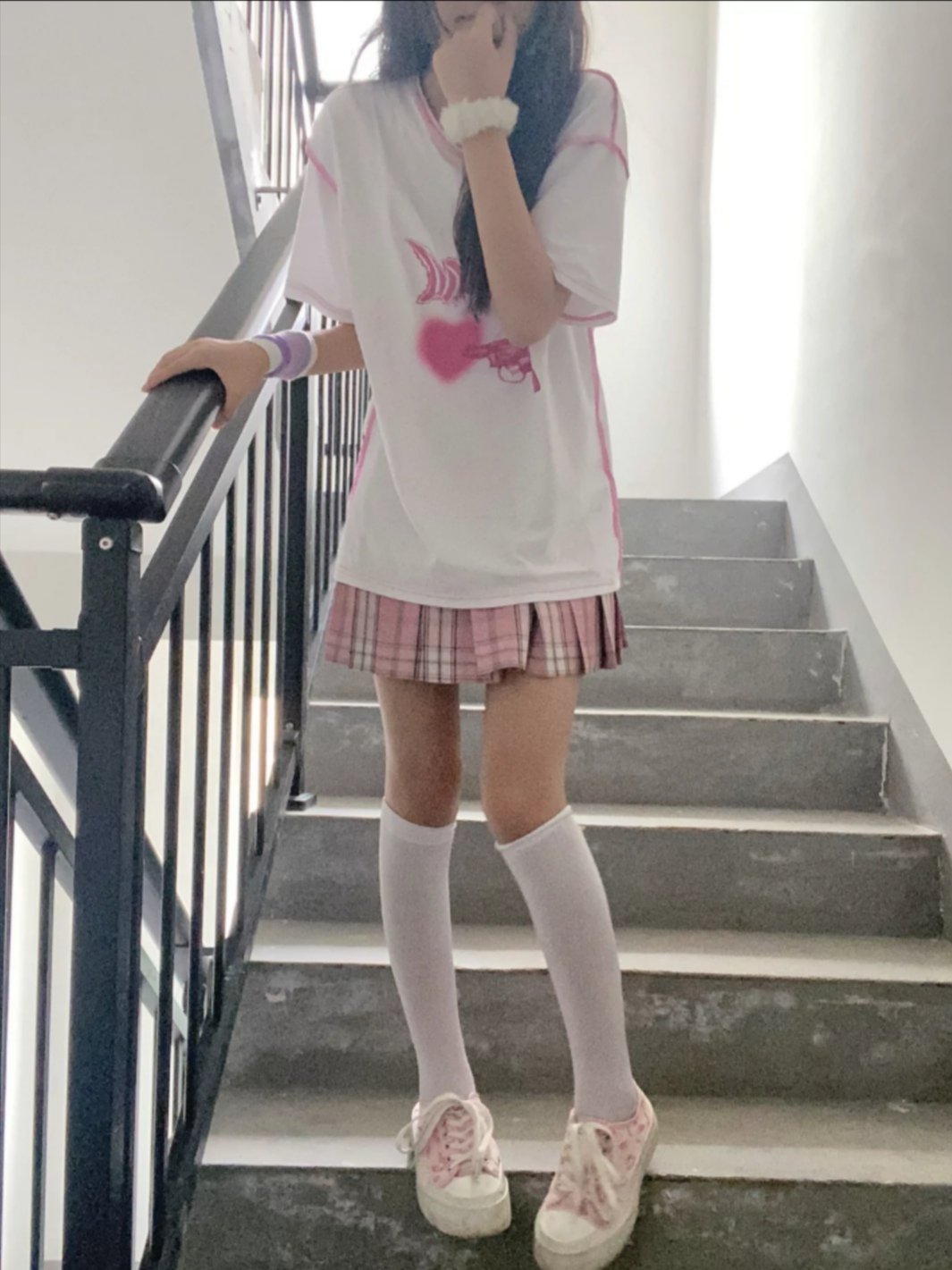 女孩穿着一件白色的衬衫,上面有一颗粉红色的心。