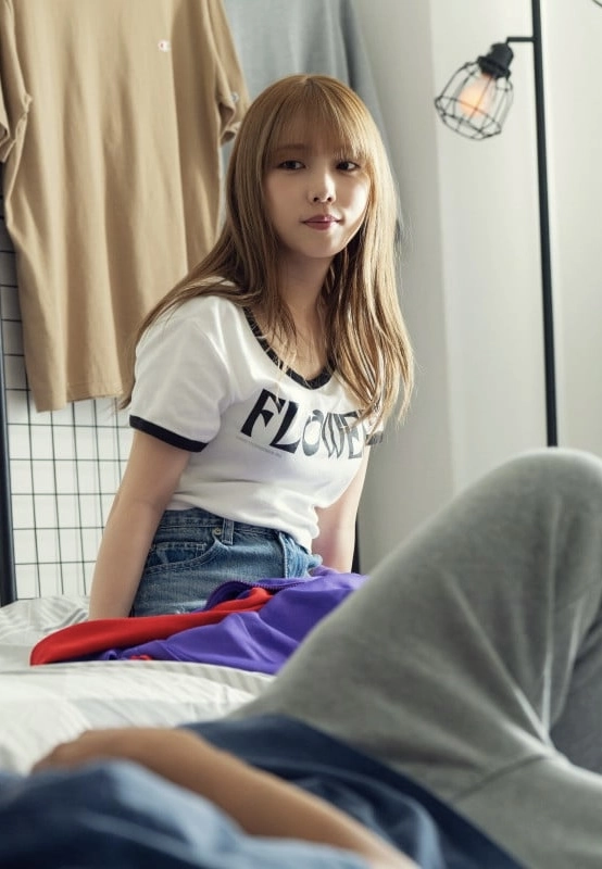 一位女人穿着一件白色衬衫,上面写着“花”。