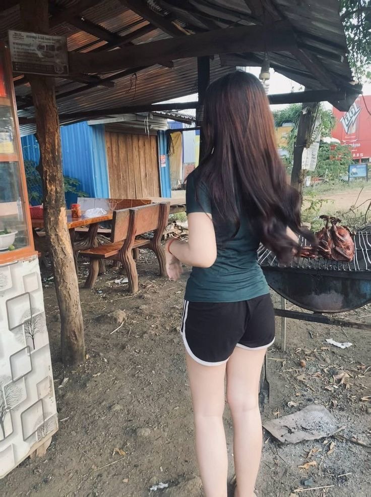 穿着绿色衬衫的女人穿过一个烤箱。