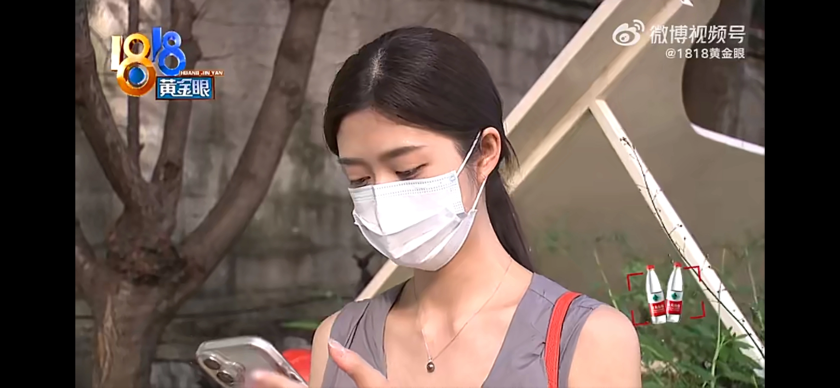 一位戴着面具的女人看着她的手机。