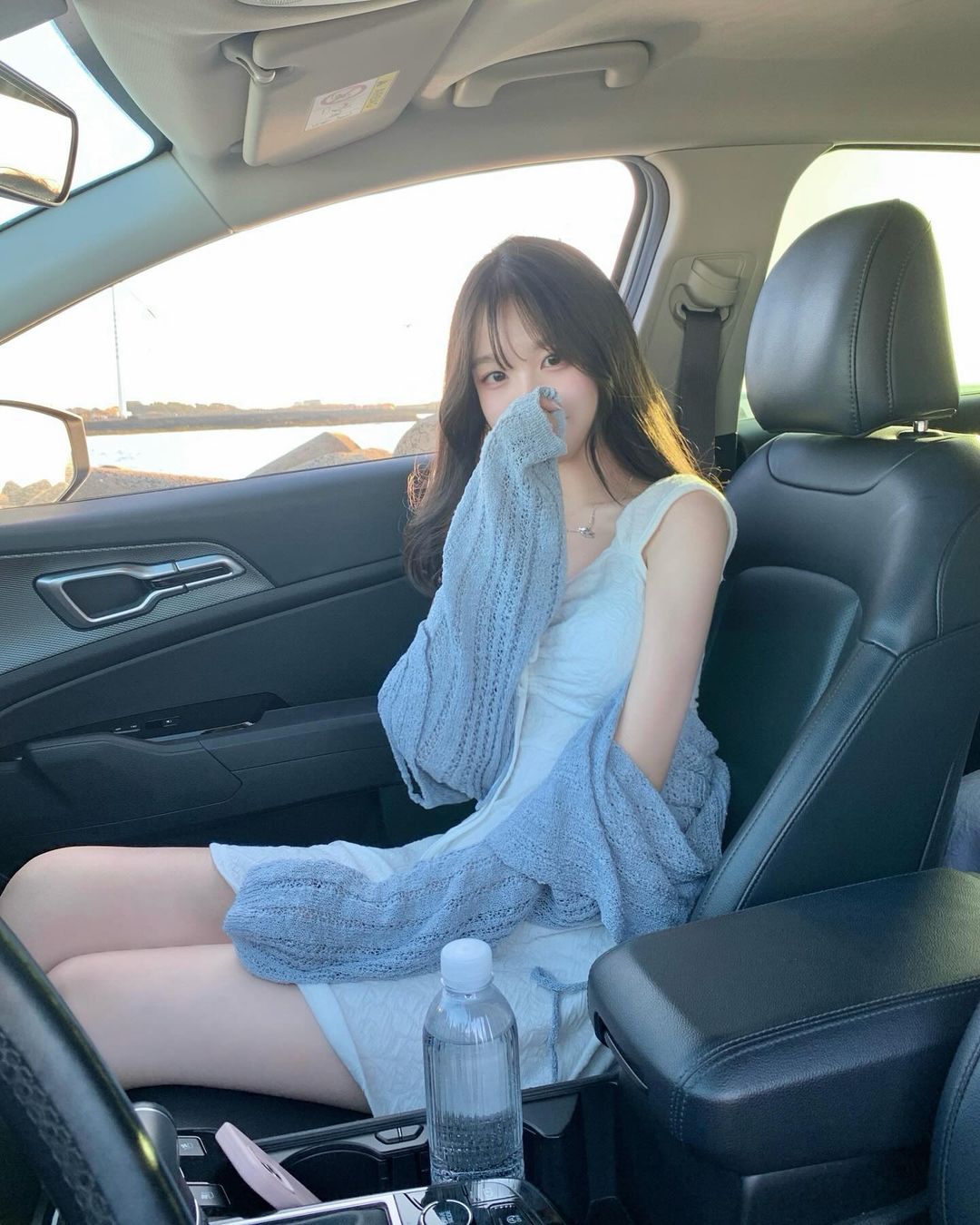 女人在车里,她的手在嘴里。