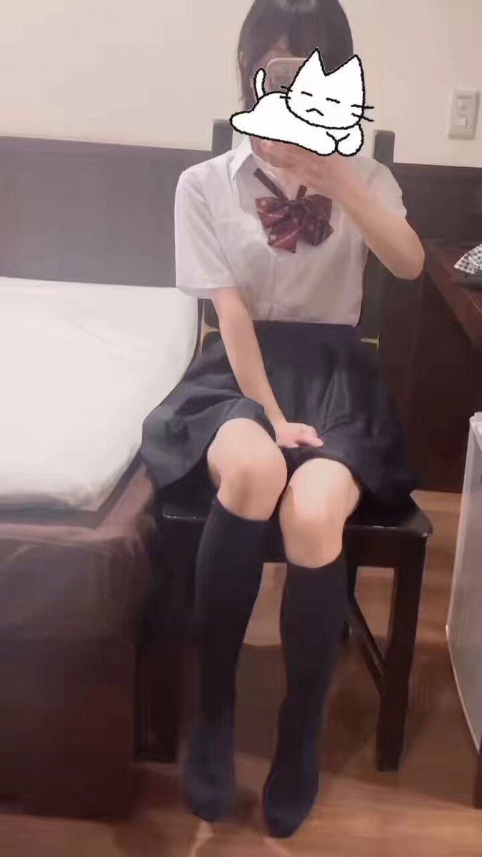 穿着白色衬衫和黑色衬衫的女人坐在椅子上。