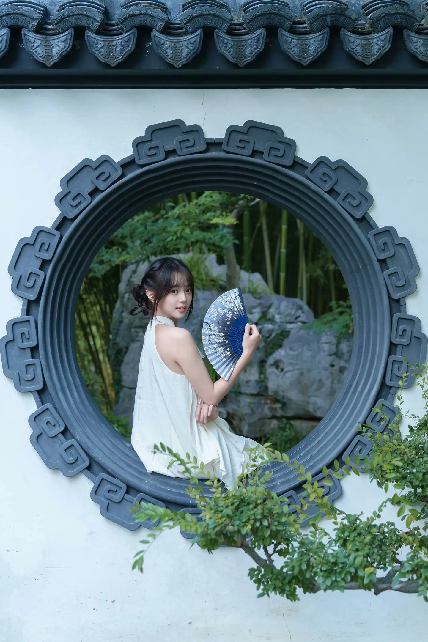 穿着白色衣服的女人拿着蓝色的伞。