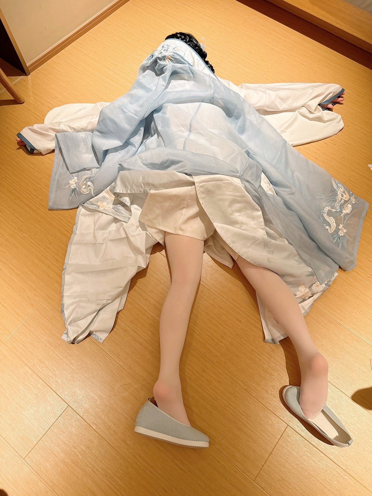 穿着蓝色衣服的人躺在地板上。