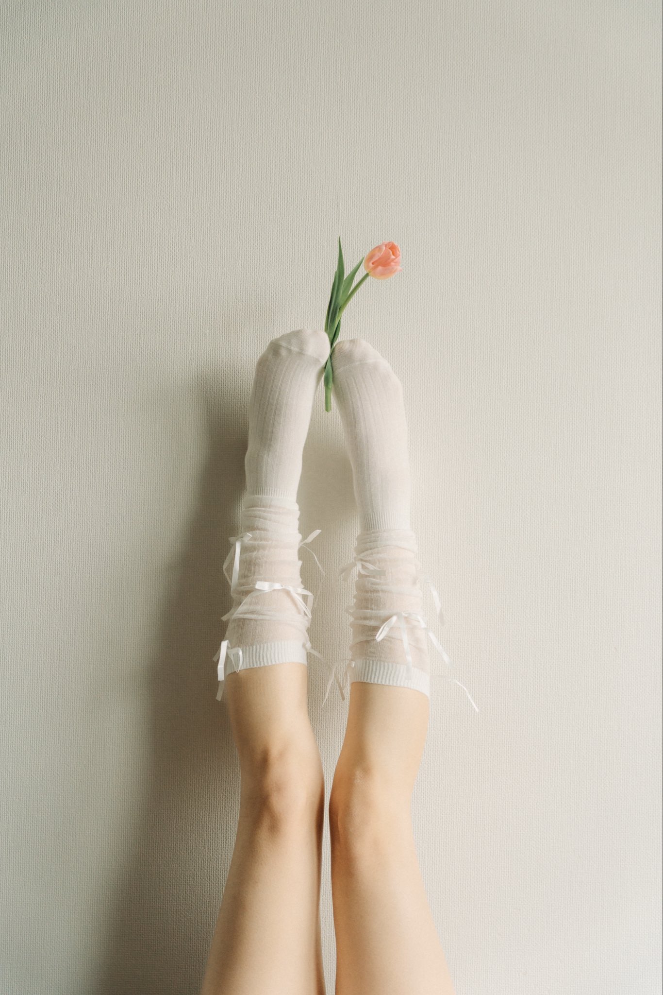 穿着粉红色的衣服的女人躺在她一边,她的腿在空中。