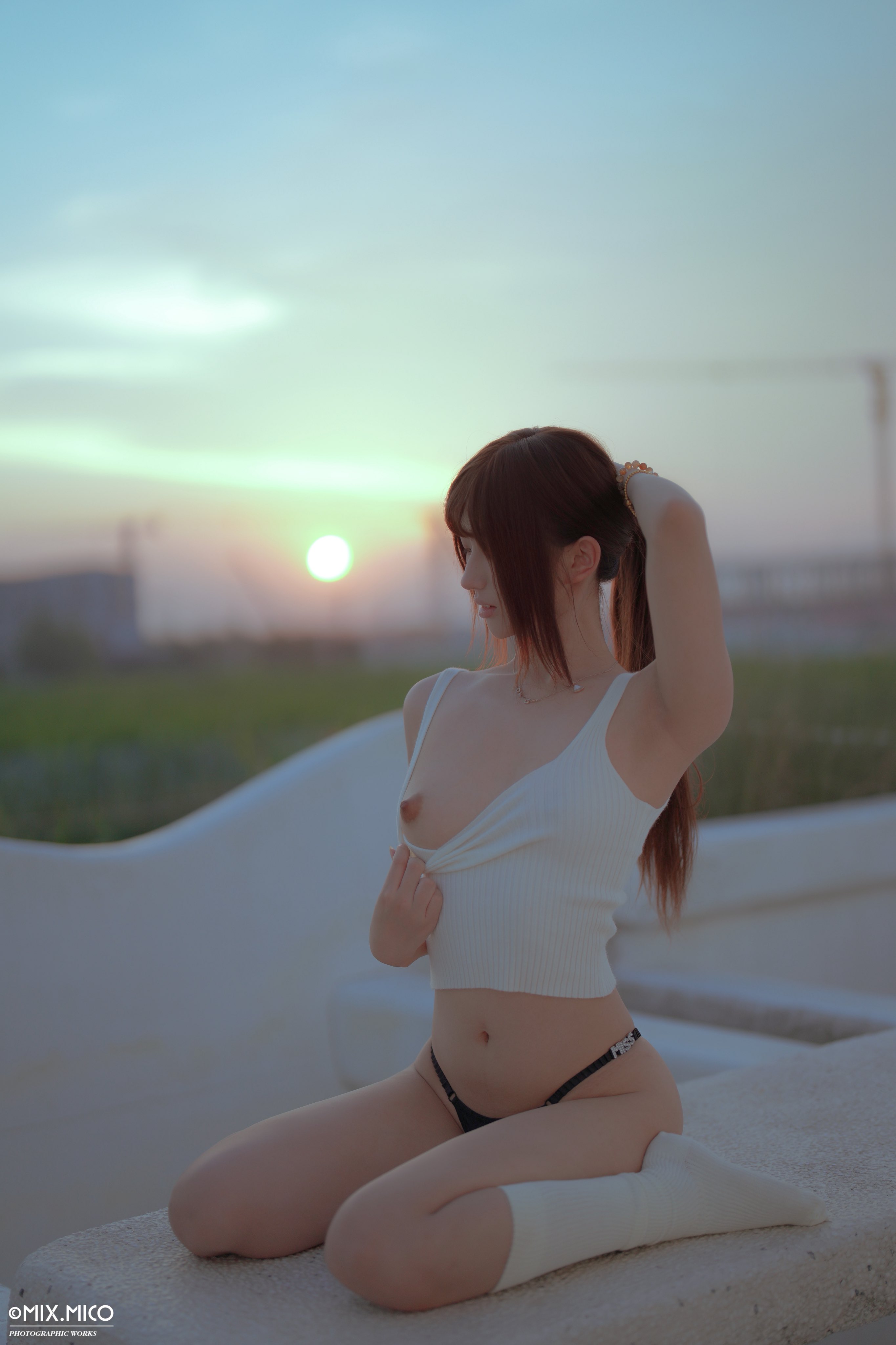 带着粉红的乳房的女人坐在一个凳子上。