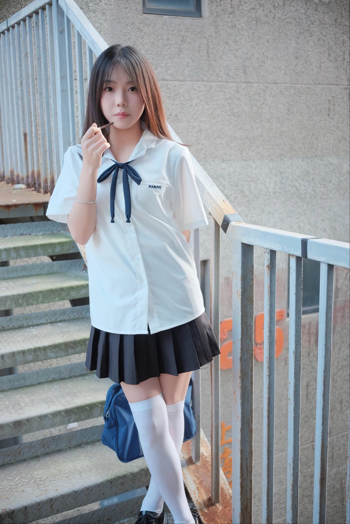 头发上有蓝弓的女孩指着一本书。