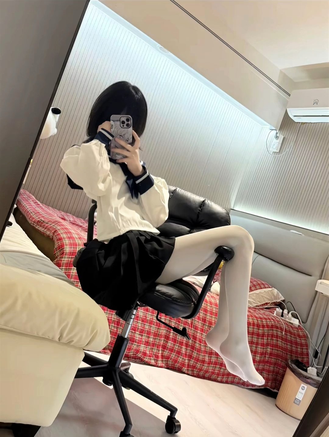 女人在一个房间里拍自拍,有床和椅子。