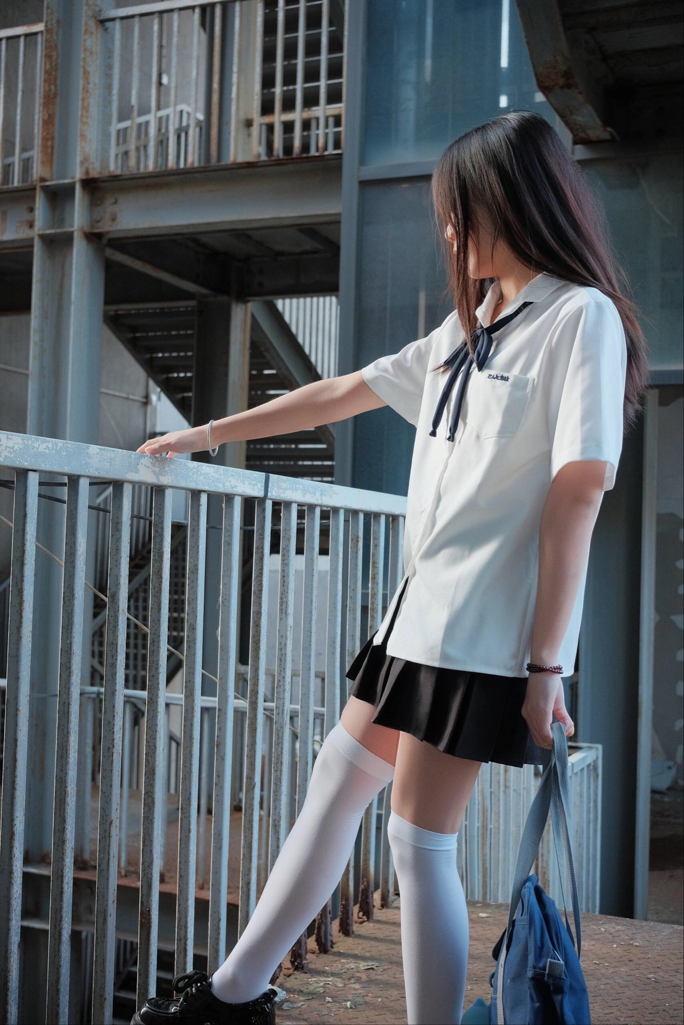 头发上有蓝弓的女孩指着一本书。