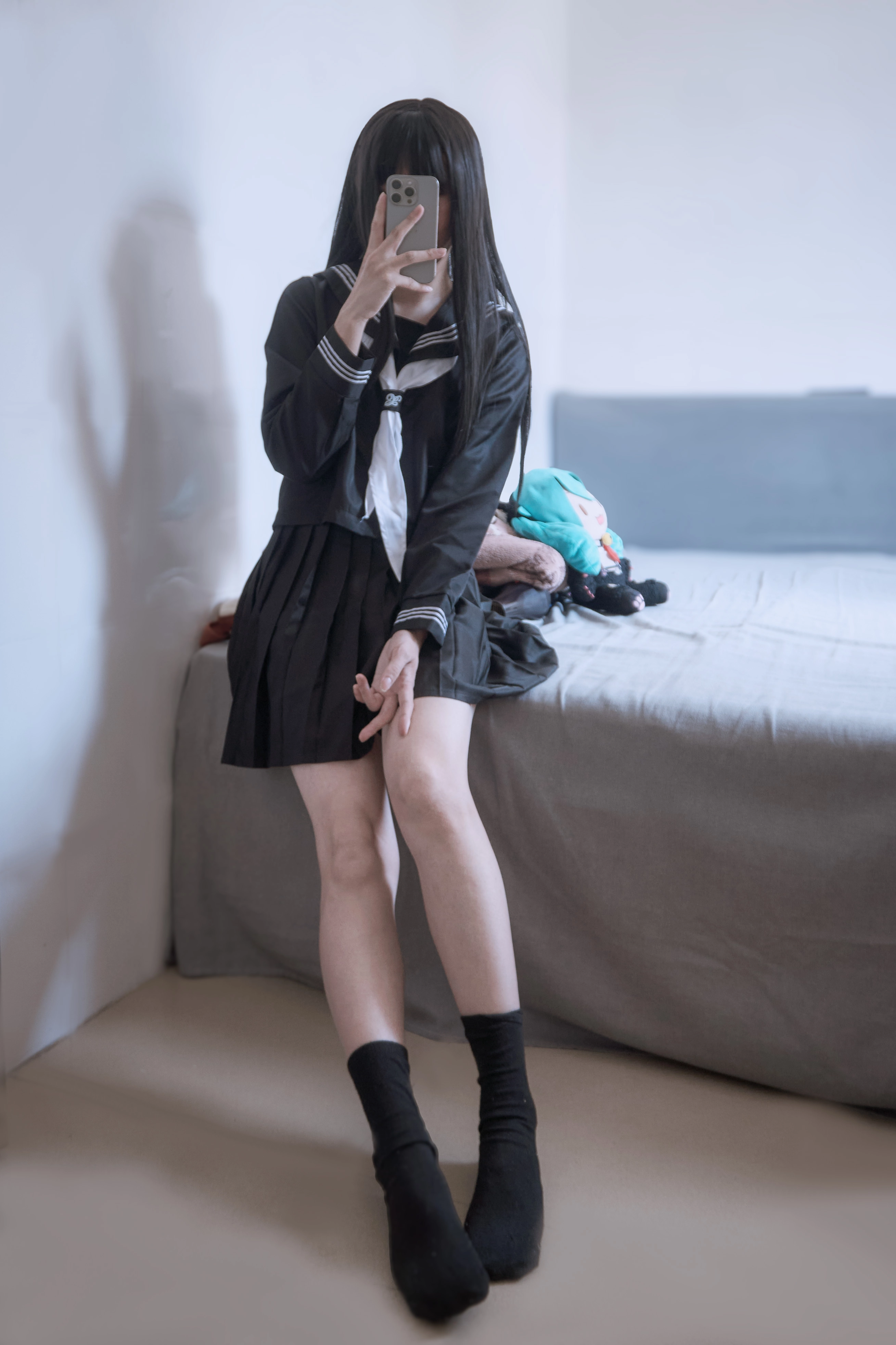 穿着黑白衣服的女孩坐在床上。