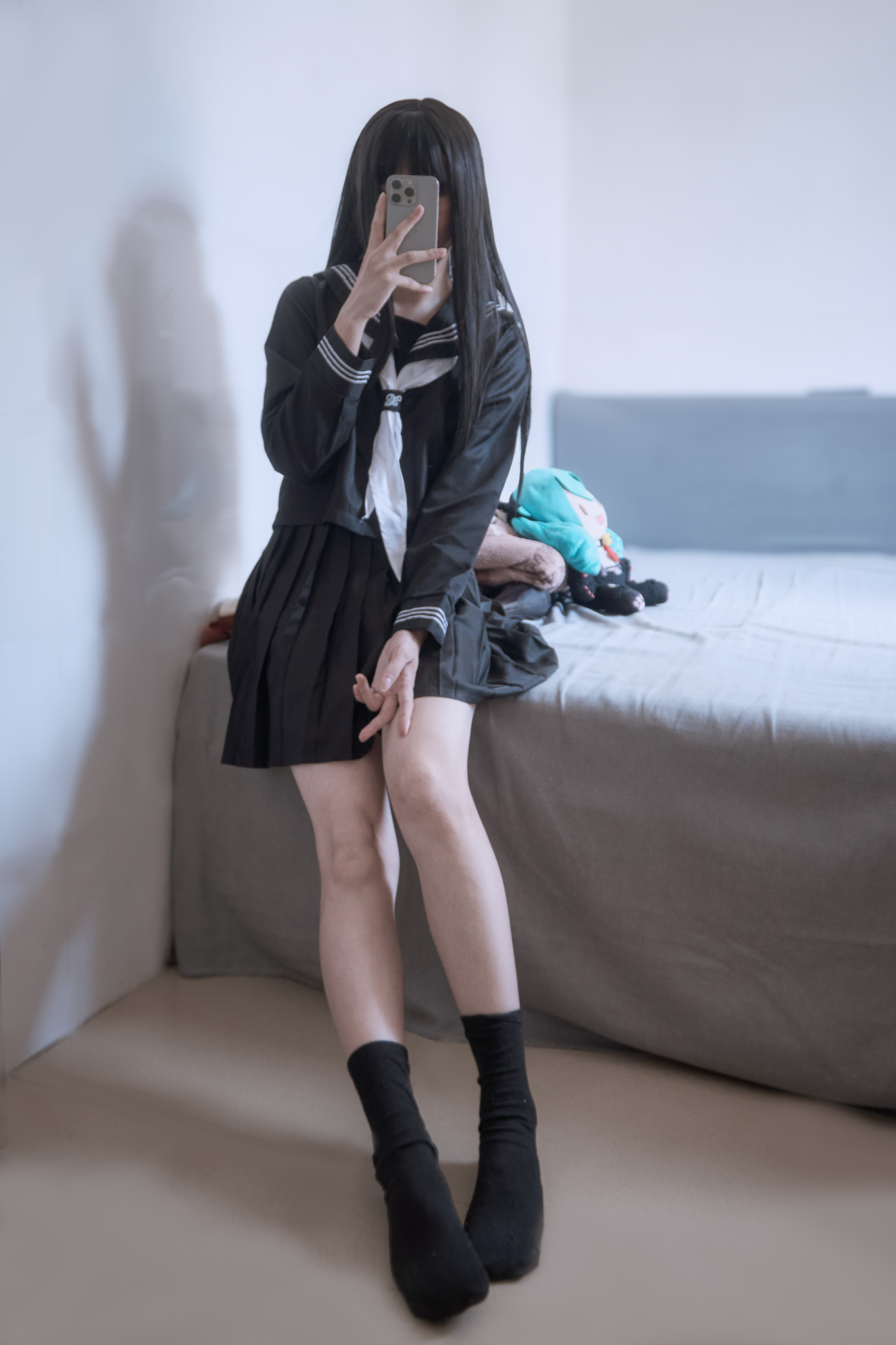 穿着黑白衣服的女孩坐在床上。