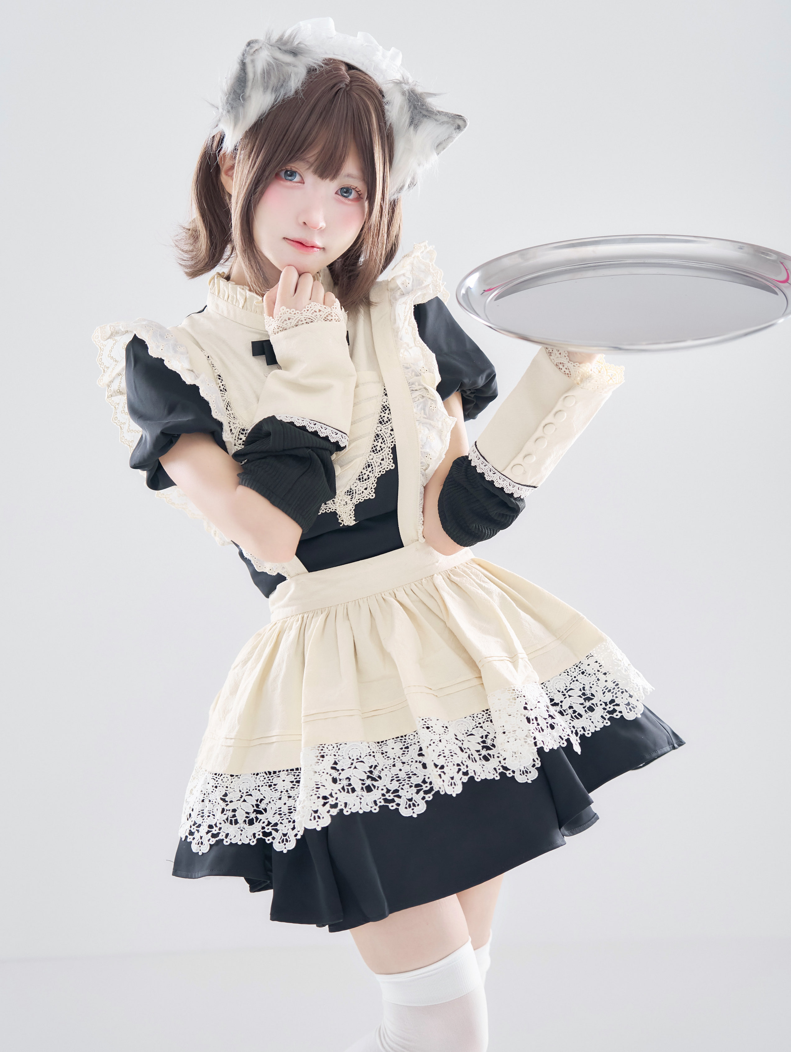 女士穿着女仆的服装,拿着一把拖拉。