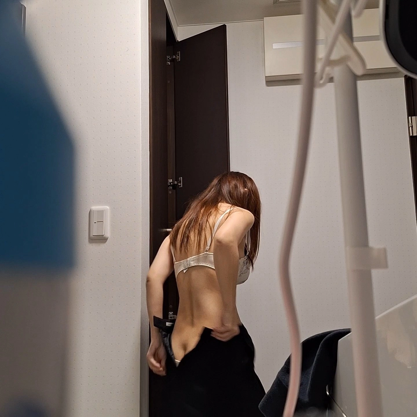 女人在浴室里打开衬衫。