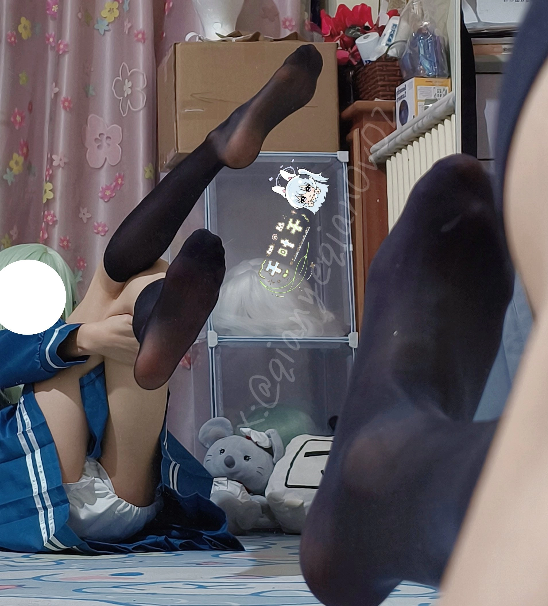 女孩坐在地板上,双腿交叉。