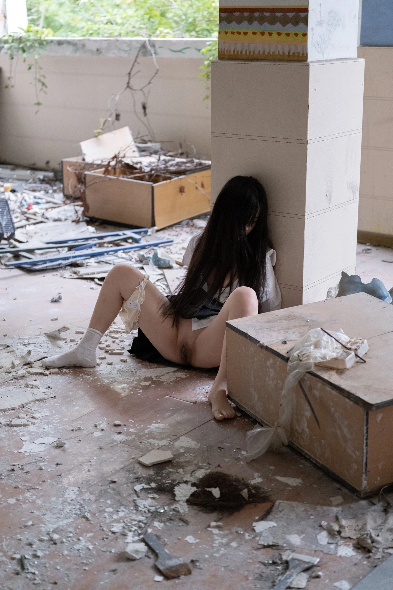 女孩坐在地板上,她的腿宽阔。