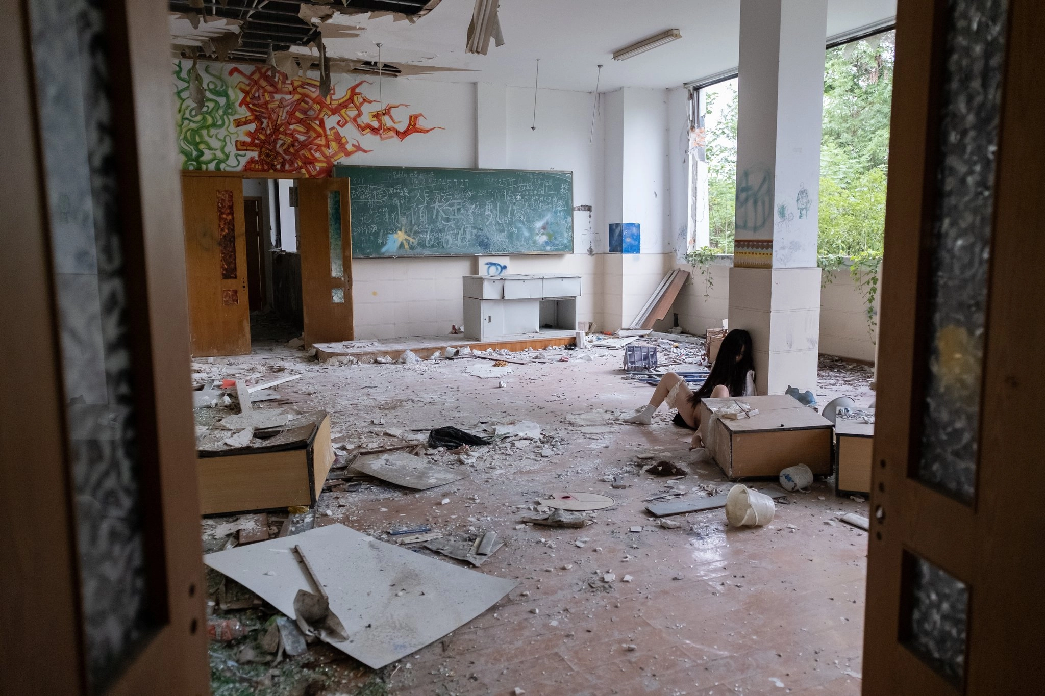 Cô gái ngồi trên sàn nhà với đôi chân rộng rãi.