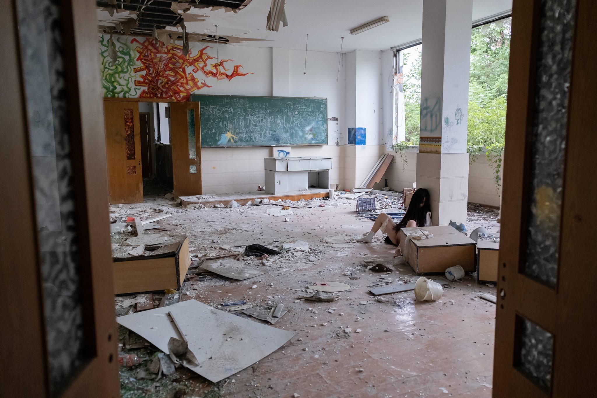 女孩坐在地板上,她的腿宽阔。