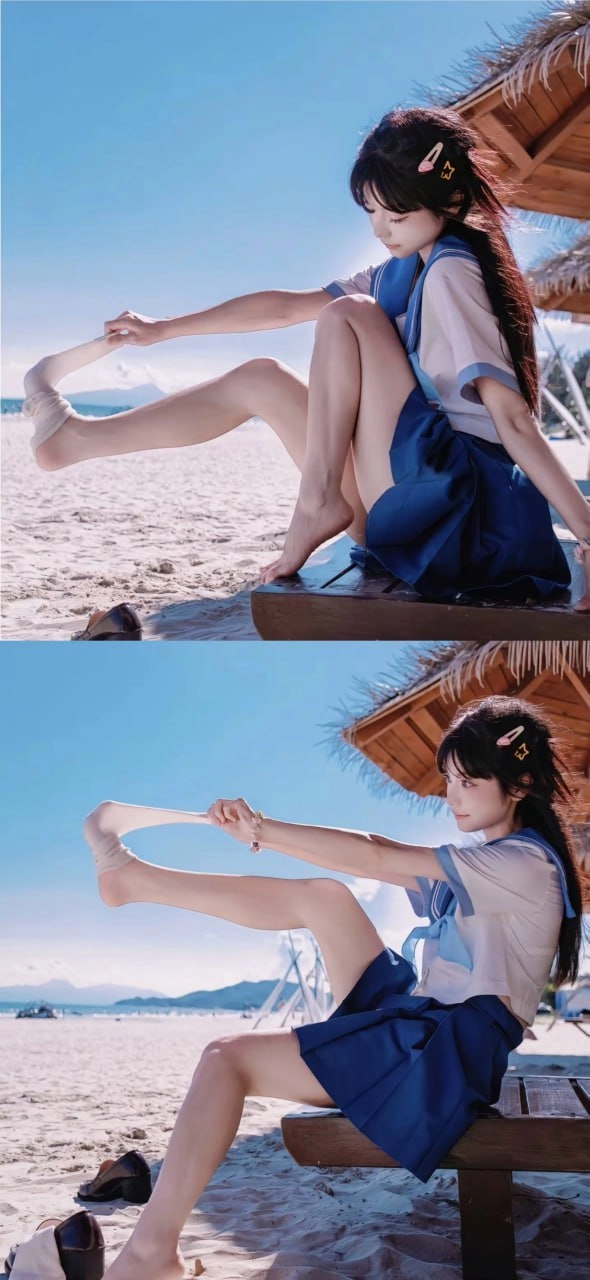 穿蓝色衣服的女人坐在海滩上。