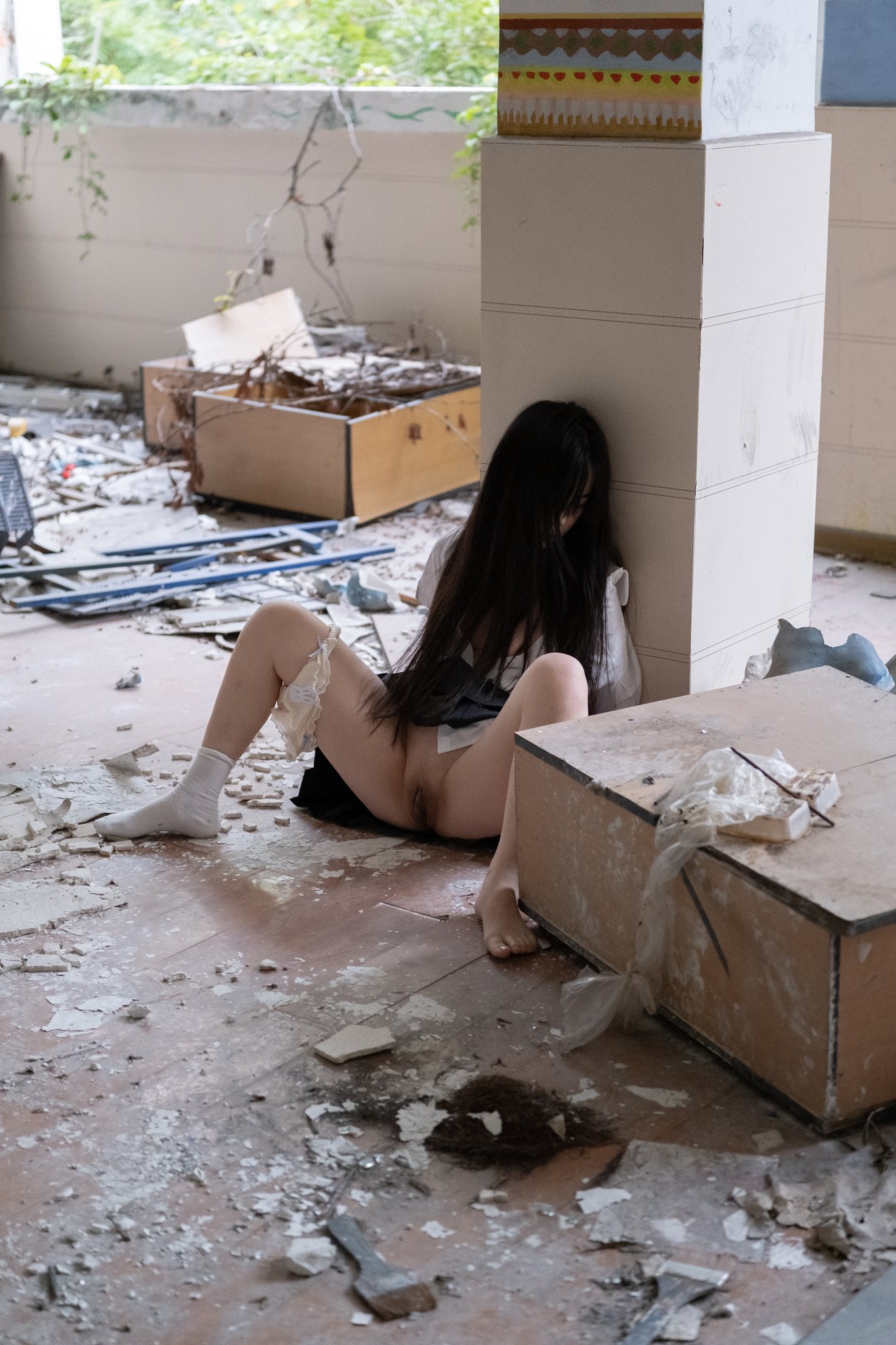 女孩坐在地板上,她的腿宽阔。