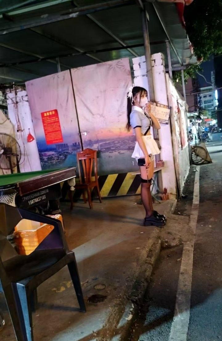 两个女孩站在黑暗的房间里,一个拿着手机。