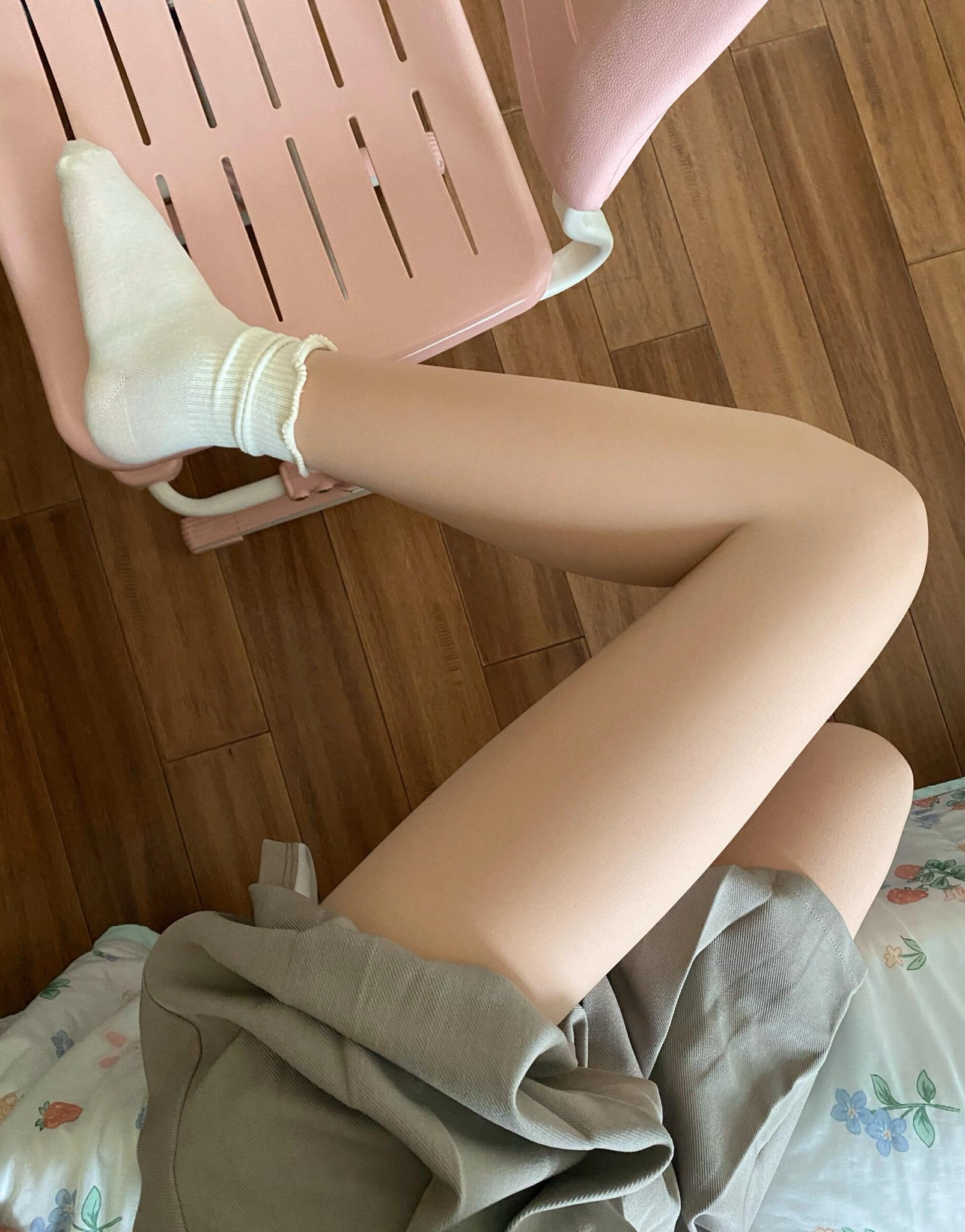 人坐在粉红色的椅子上,双腿交叉。