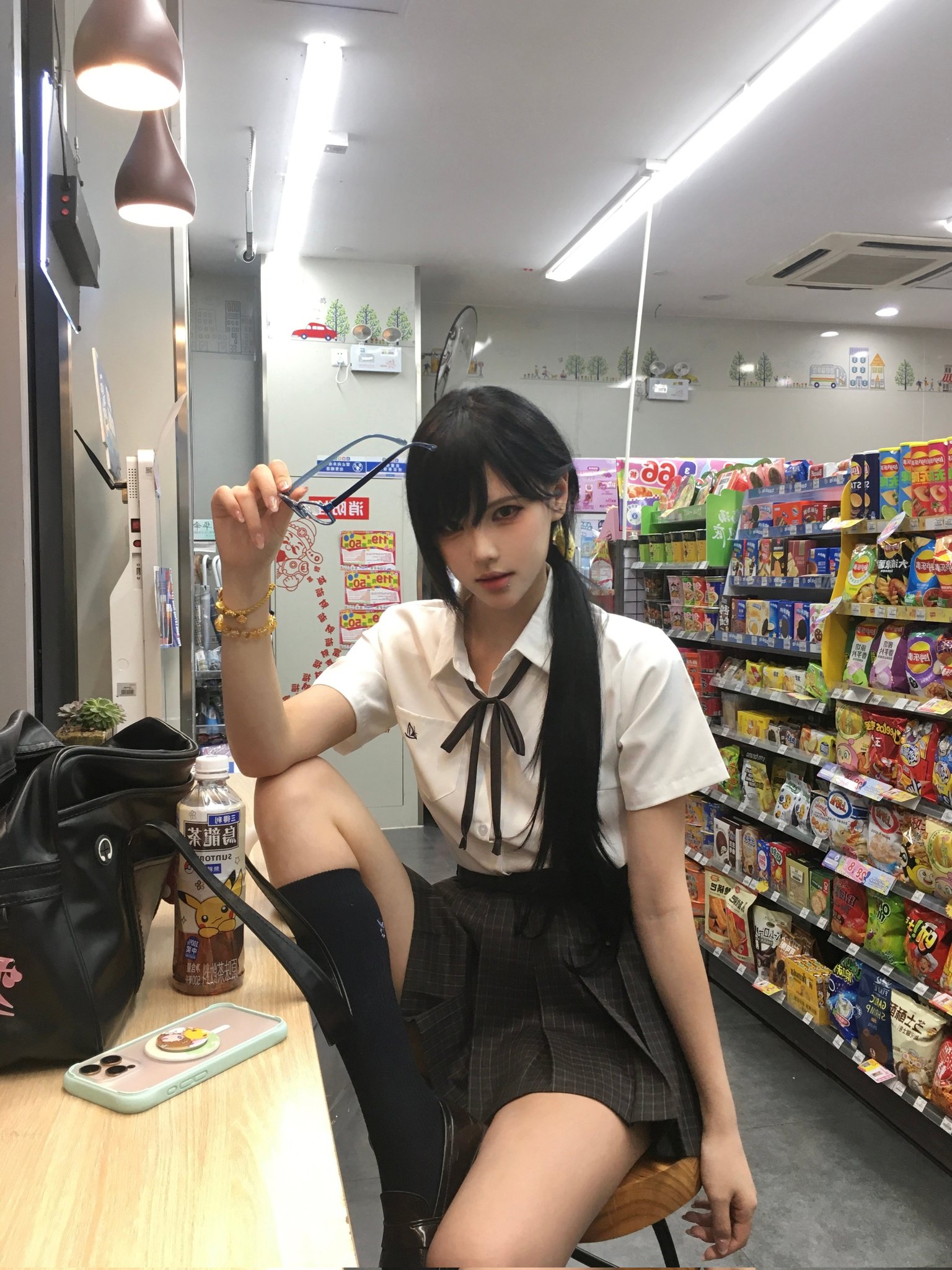 穿着白色衬衫和黑色裙子的女人拿着一双眼镜。