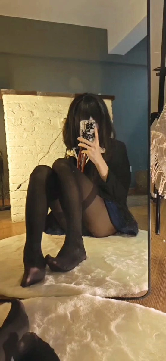 女人在镜子前拍自拍。