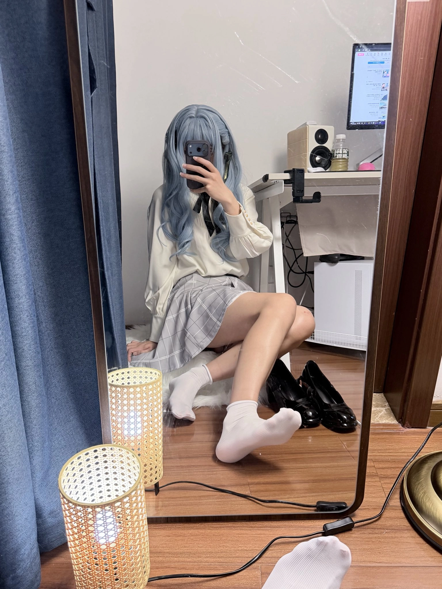 一位穿着白色衬衫和黑色衬衫的女人在镜子前拍自拍。