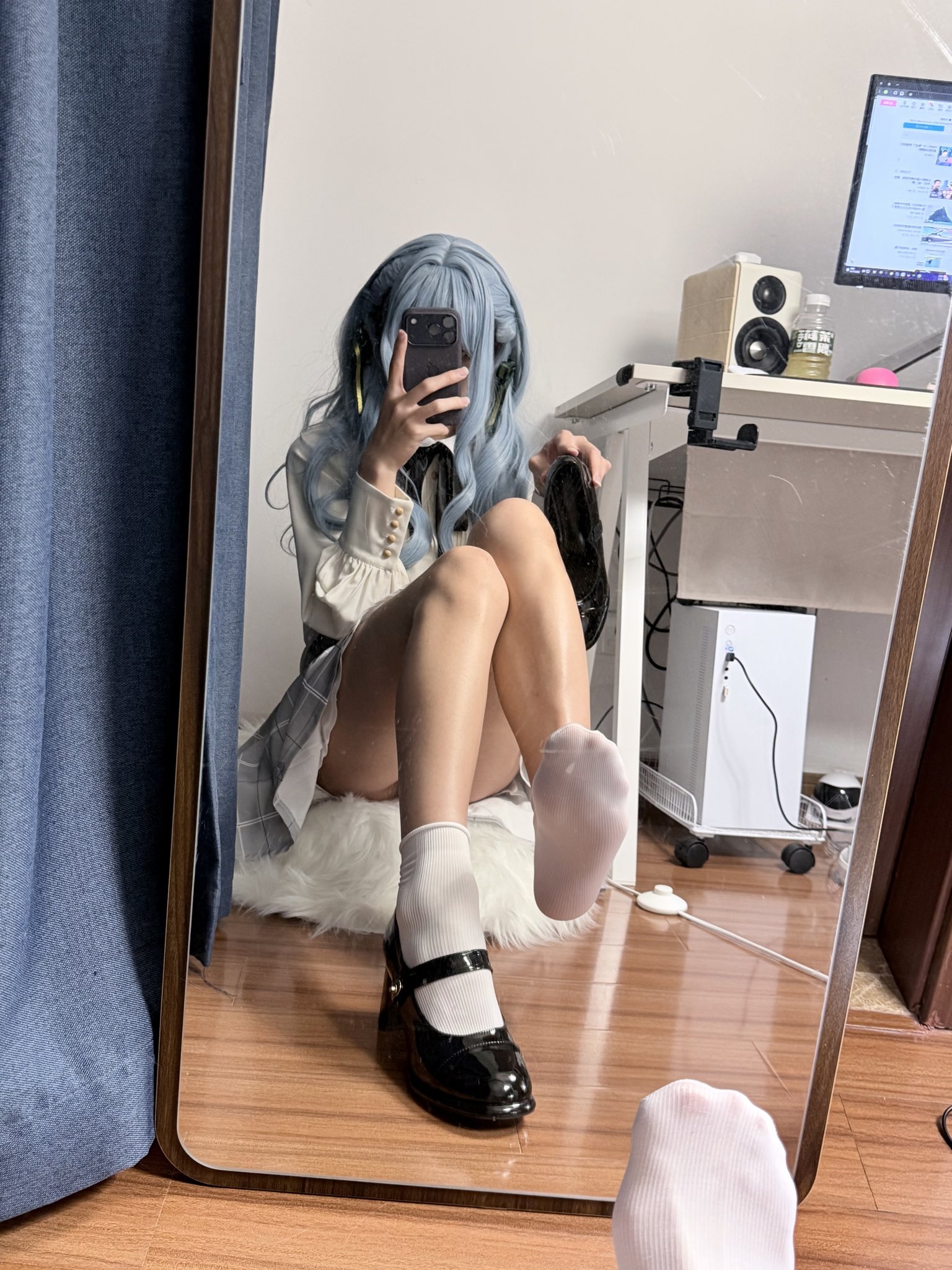 一位穿着白色衬衫和黑色衬衫的女人在镜子前拍自拍。