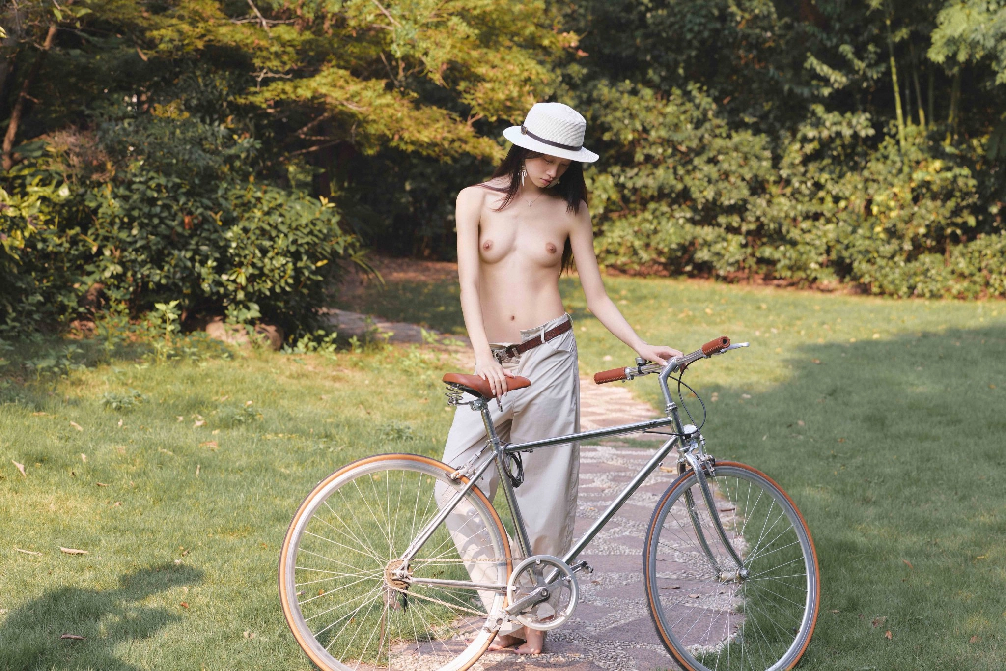 没有衬衫的女人站在自行车旁边。