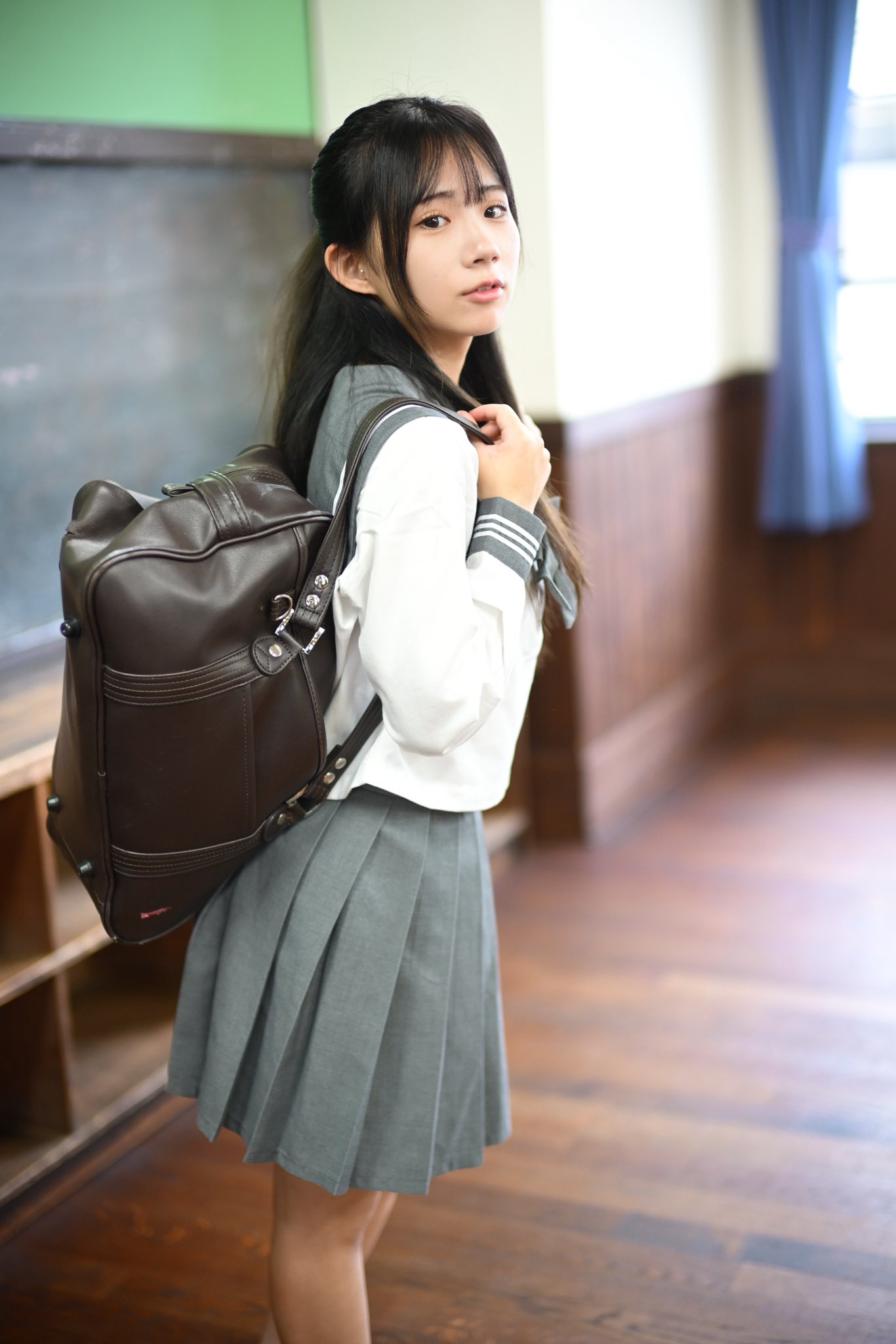 穿着水手服的女孩站在门口。