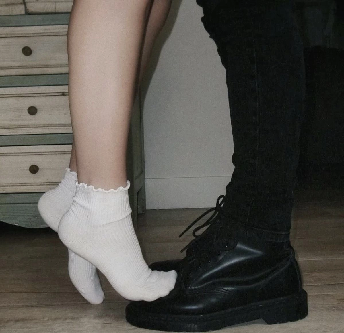 穿着黑靴子的男人抱着一个女人在他的怀里。