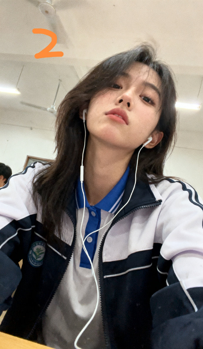 穿着蓝色夹克和黑色头发的女孩正在做和平的信号。