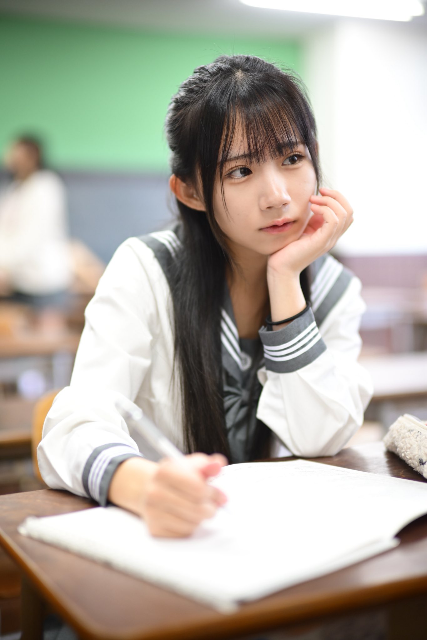 穿着水手服的女孩站在门口。