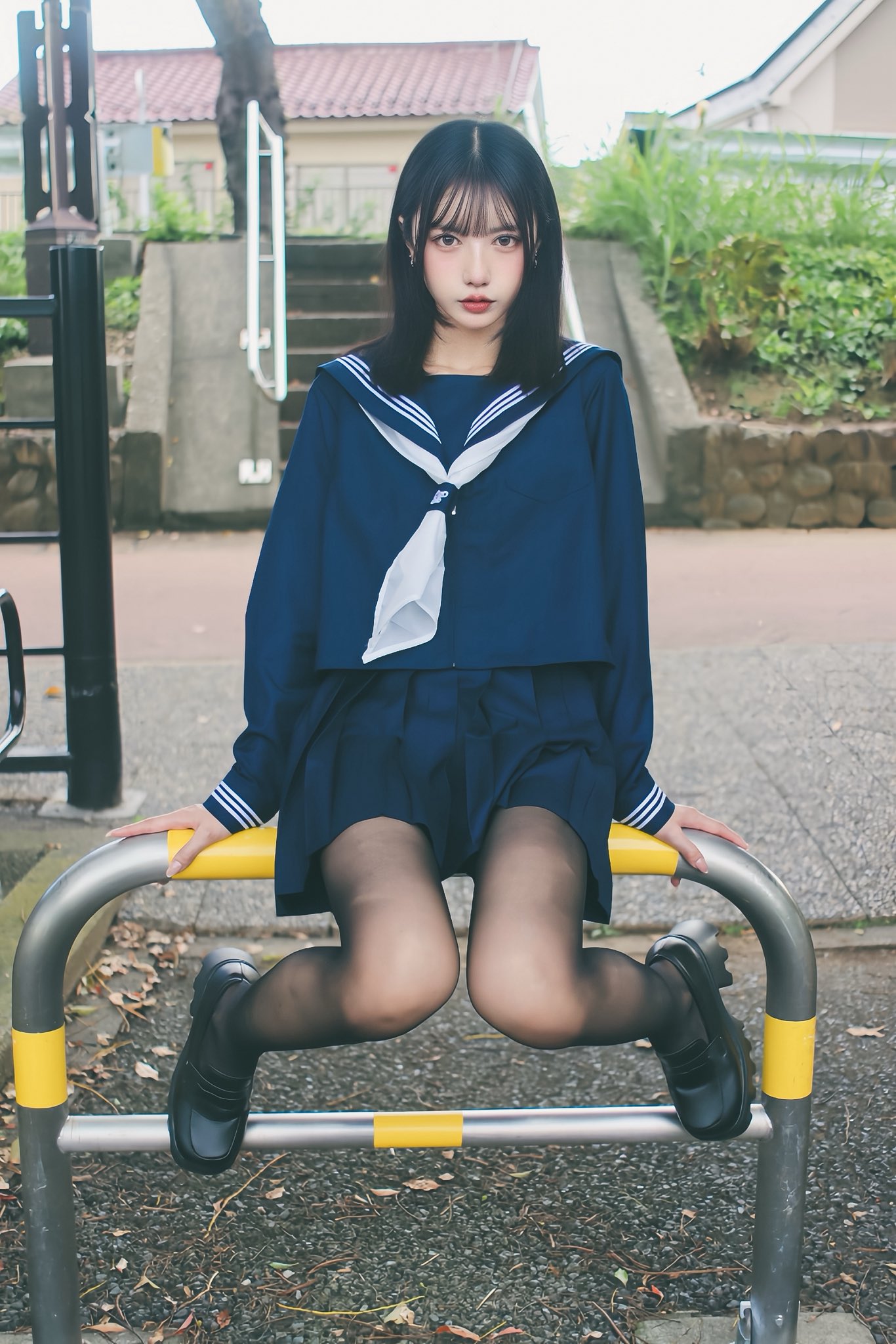 穿着蓝色衬衫和领带的女人坐在一个黄色极上。