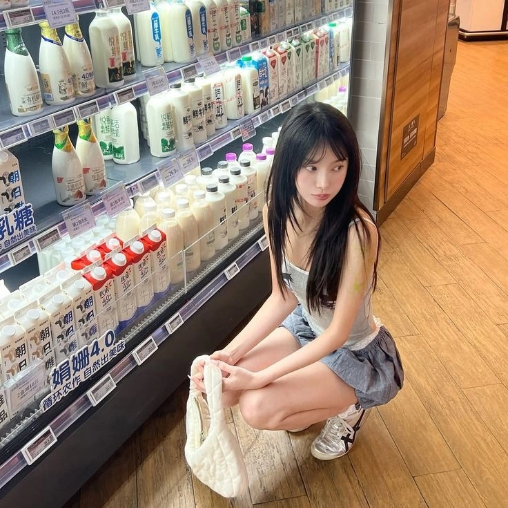 女人跪在牛奶展览前。