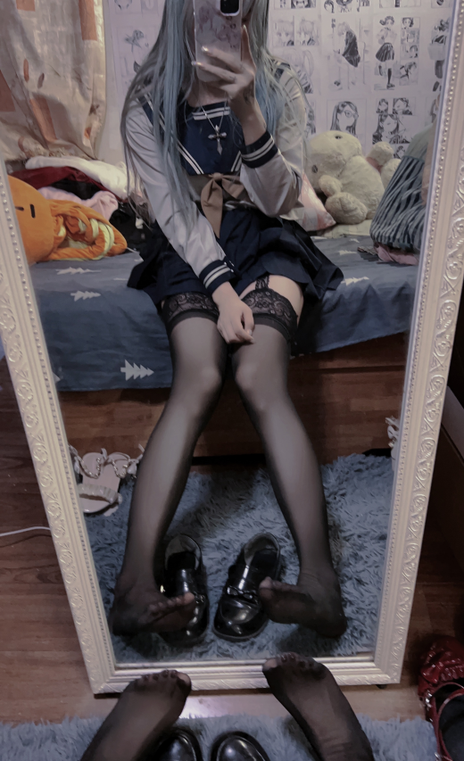 穿着水手服的女人坐在床上。