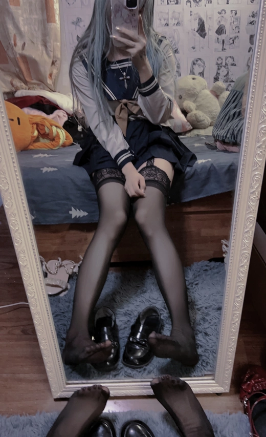 穿着水手服的女人坐在床上。