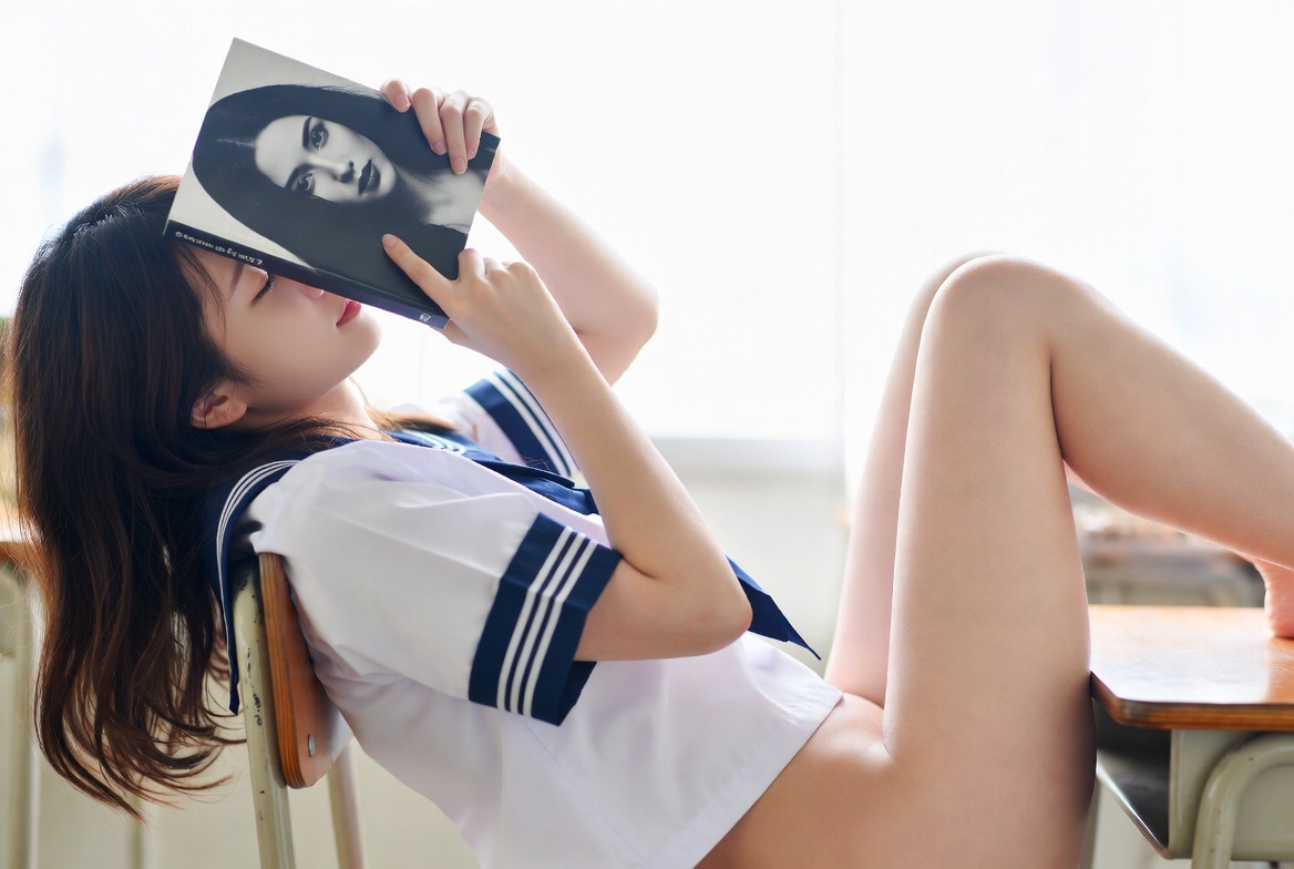 一位穿着白色衬衫和蓝色条纹的女人正在读一本书。