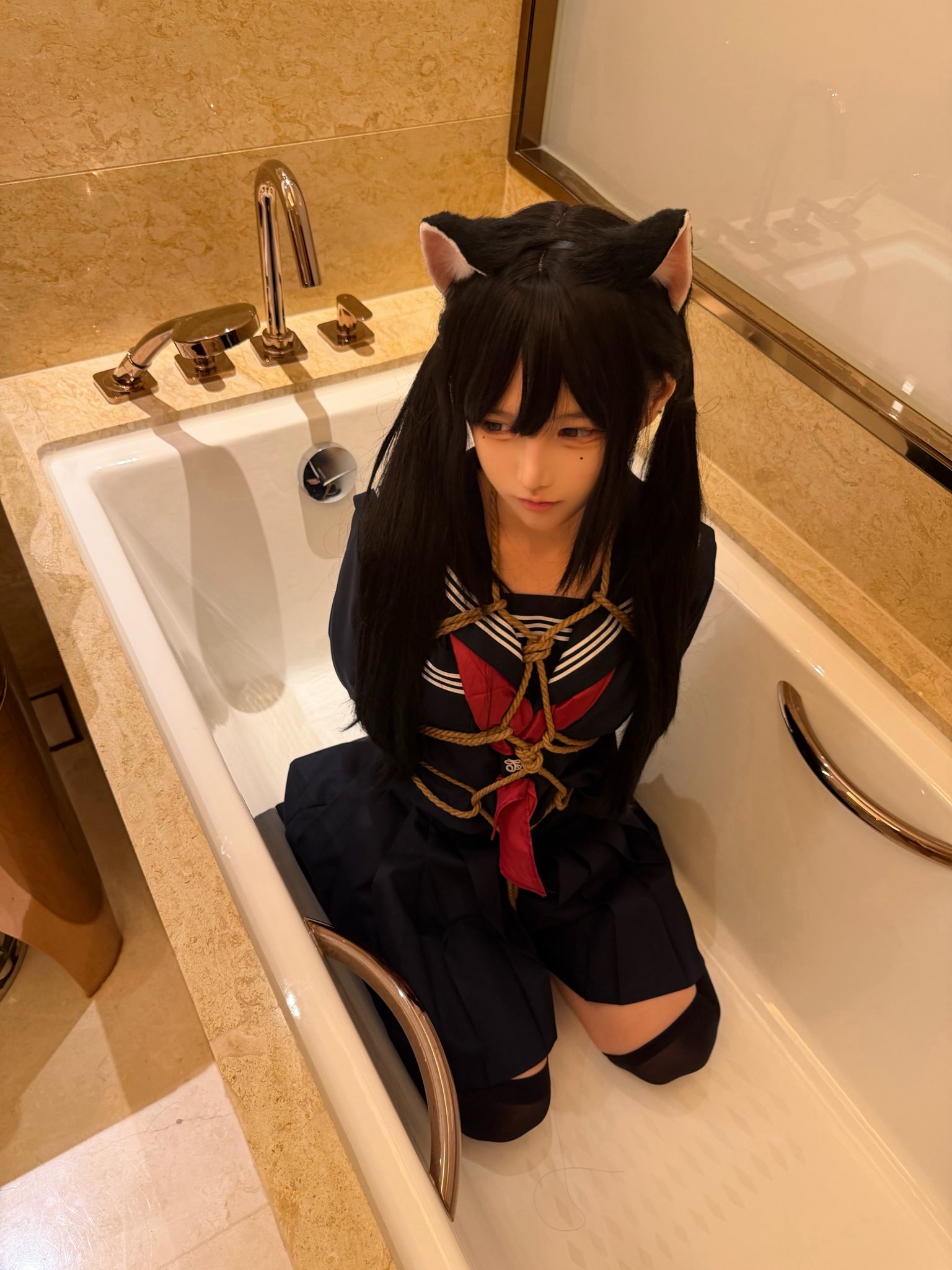 穿着黑色衣服的女孩坐在浴缸里。